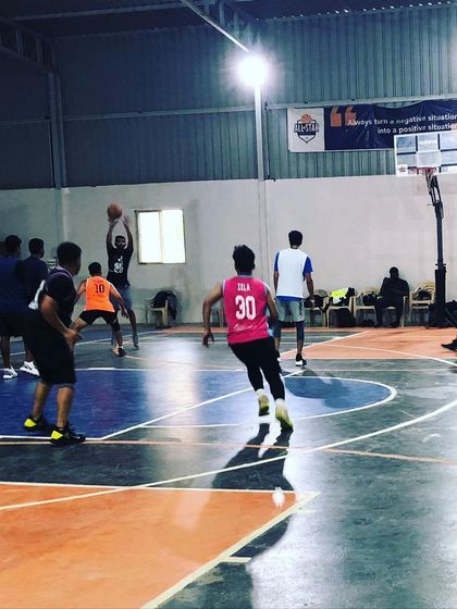 A player takes a shot from the key. Our court is equipped with professional hoops and a clearly marked playing surface for an authentic experience.
