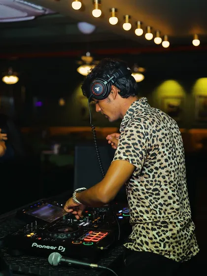 In the zone, mixing tracks and feeling the energy of the room. This is me during a live DJ set, focused on crafting the perfect sound for the night on my Pioneer DJ console.