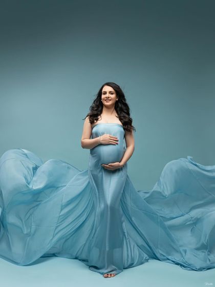 A confident and happy pose, centered in the frame with the blue fabric creating a perfect wave on either side.