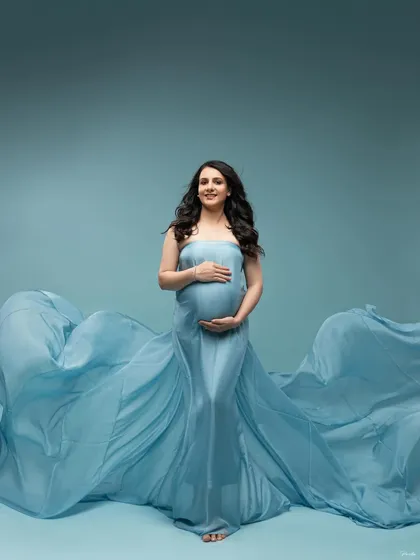 A confident and happy pose, centered in the frame with the blue fabric creating a perfect wave on either side.