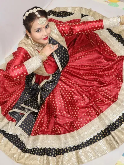 A costume is not complete until it is brought to life by the artist. Here, a dancer embodies grace in a custom-designed red and black anarkali, its voluminous ghera creating a perfect circle in a classic Kathak pose.