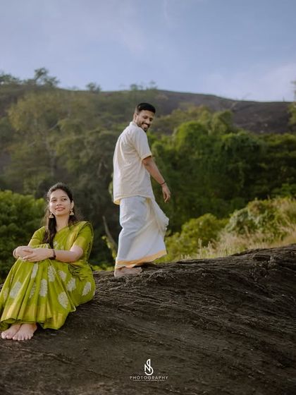 A playful, candid shot that captures their personalities. The natural setting of the hills near Sullia provides a beautiful, rugged backdrop.