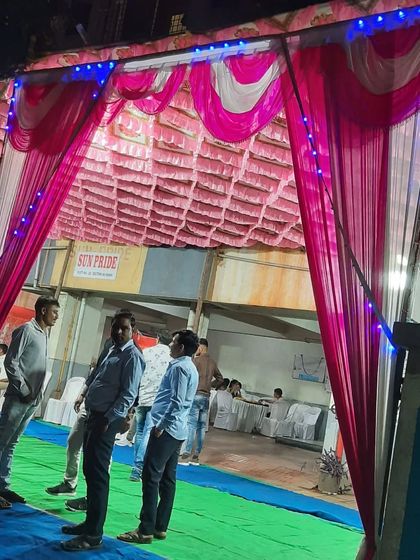The entrance to a pandal at night in Vashi. The lighting and drapes create a festive welcome.