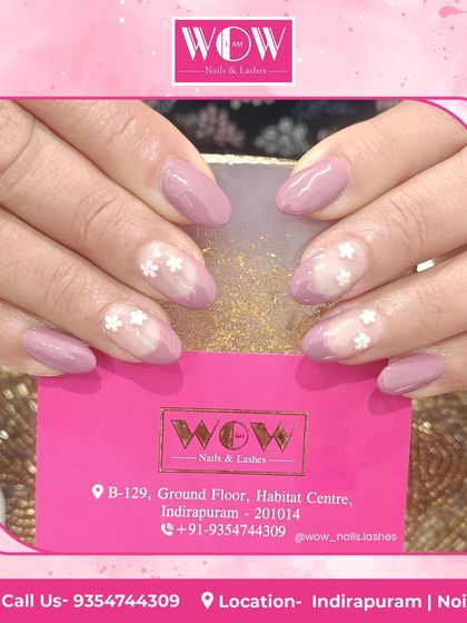 A soft and pretty floral design. This look features a mauve base with delicate, hand-painted white flowers on sheer accent nails.