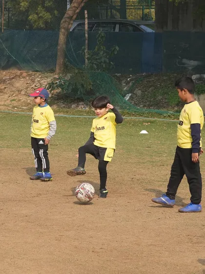 Three young players practicing their footwork. Happiness and growth intertwine as they develop skills and character through these focused drills.