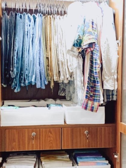 In this wardrobe, we used white fabric bins to create "drawers" on open shelves. This is a great solution for closets that lack built-in drawers, providing containment and easy access.
