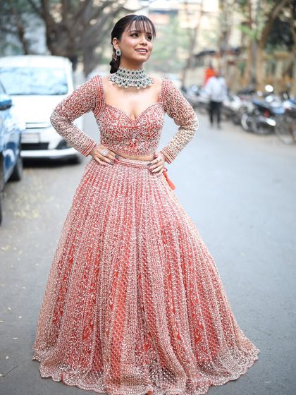 A happy and confident pose in the pink Sangeet lehenga, paired with a statement diamond look choker.