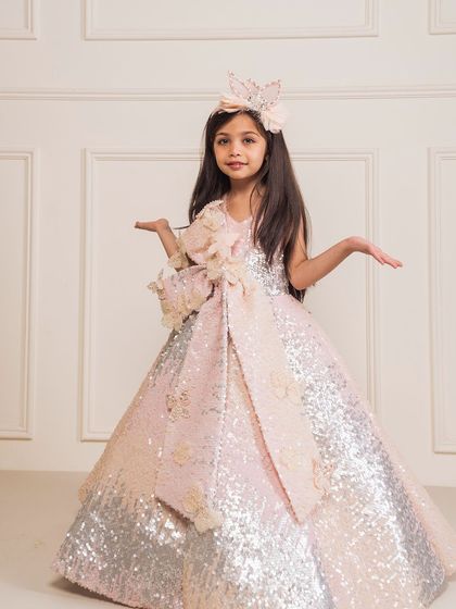 A playful pose showing the full, sparkling skirt of the ombre sequin gown.