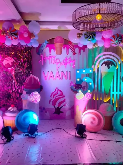 A vibrant and sweet Candyland themed birthday party, filled with giant candy props, ice cream cutouts, and a colorful neon sign.