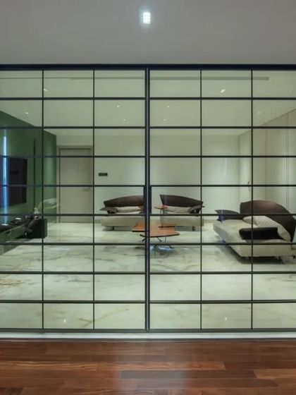 The gridded glass doors when closed, creating a "room within a room" effect. This design feature offers flexibility while adding an industrial-chic element to the interior.