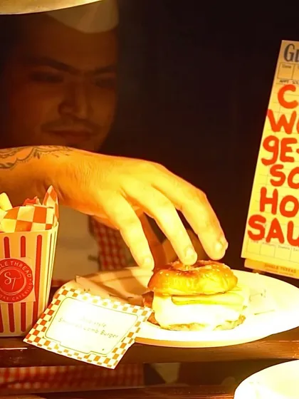 My live burger stations are always a crowd-placer. A chef carefully assembles a gourmet smash patty burger, complete with all the fixings, showcasing the hands-on, fresh-to-order quality of my interactive catering.