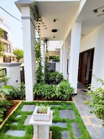 A well-designed entrance sets the tone for the entire home. We used a mix of ground-level planters, climbing vines, and a patterned lawn with stone pavers to create a welcoming and elegant pathway that is full of life.