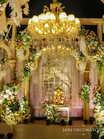 For a divine and opulent ceremony, I framed the sacred space with grand arches overflowing with white and gold florals. A magnificent chandelier and a central Ganesha idol add blessings and grandeur to the setting.