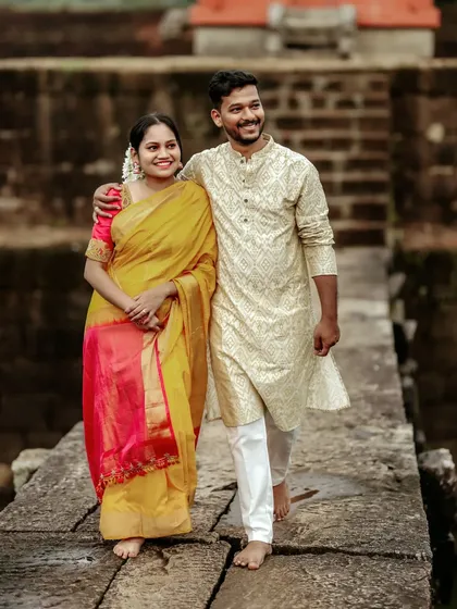 Maternity photos can be beautifully traditional. This couple, dressed in elegant Indian attire, shares a moment on a rustic stone bridge, blending cultural grace with the natural beauty of the surroundings for their pregnancy photoshoot.