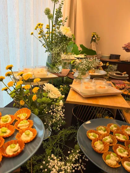 A close-up of a festive grazing table, adorned with yellow and white flowers. This shot features our bite-sized tartlets and other appetizers, perfect for a pre-Rakhi celebration.