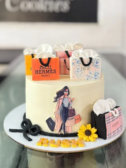 A shopaholic's dream cake, decorated with edible shopping bags from luxury brands like Hermes, Dior, and Burberry.