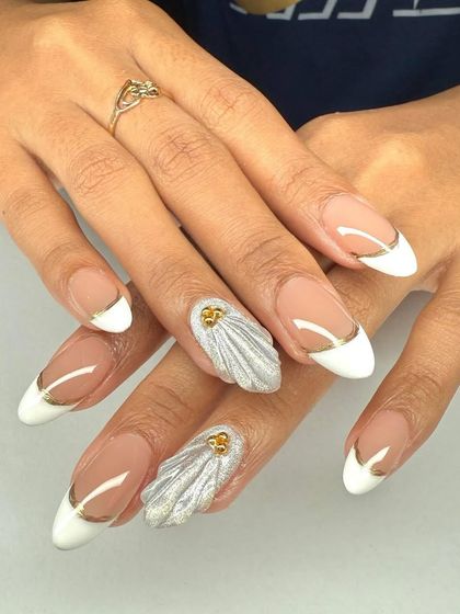 A statement French manicure with 3D silver shell accents and delicate gold lines over the white tips.