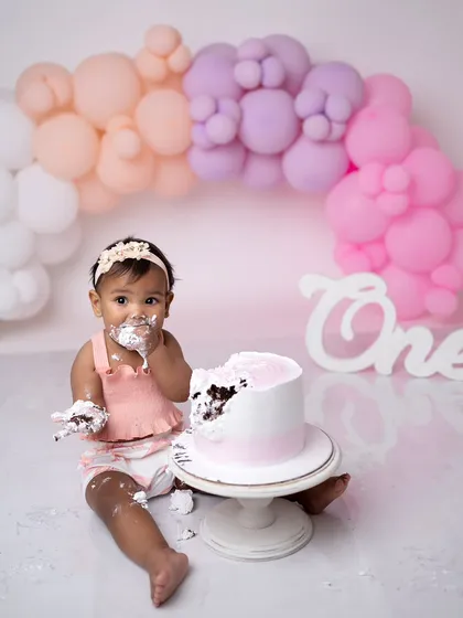 Nothing says "first birthday" like a cake smash! This shot captures the pure, messy joy of a baby digging into their cake for the first time.