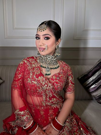This bride is radiating pure bliss in her red lehenga and our heavy polki choker set with green accents. A perfect example of a modern yet minimal bridal look.