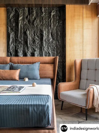 For the Rustic Reverie apartment, I designed this master bedroom to be a sanctuary of texture. A custom-chiseled stone panel serves as a dramatic backdrop, balanced by the warmth of wood paneling and a rich leather bed frame, creating a space that is both bold and serene.