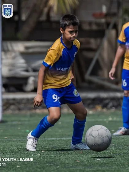 A U11 player looking up to make a pass, demonstrating good game awareness.