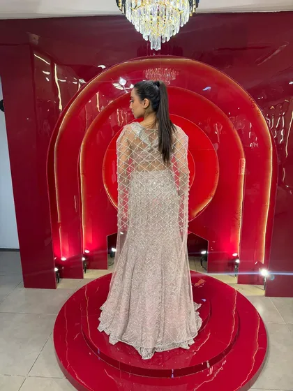 The back of this lehenga is just as stunning as the front. The sheer cape features a beautiful lattice pattern in silver embroidery, adding a touch of drama and elegance.