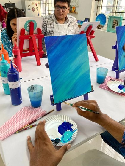 A close-up of a participant painting a blue gradient on canvas. Learning to blend colors smoothly is a key skill we practice in my workshops.