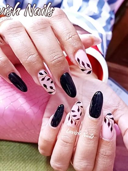 A chic combination of glossy black nails and accent nails with a black leaf pattern on a sheer base.