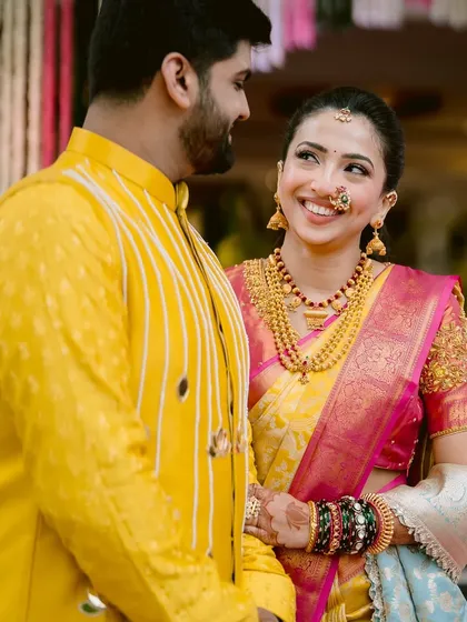 A candid moment of love. The bride's makeup was designed to look fresh and radiant, with a focus on her smile. The traditional Maharashtrian nath and jewelry complete her joyful bridal look.