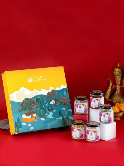 Another festive shot of a Valley Culture gift set, this time against a rich red background. The use of traditional Indian decor elements enhances the celebratory feel.
