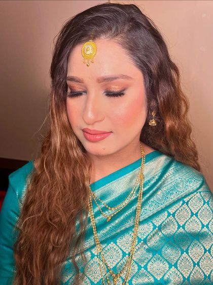 A close-up of the soft, golden eye makeup that complements her traditional silk saree.