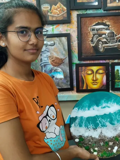 Another shot of our student with her beach-themed resin piece, with our studio's inspiring gallery of artworks in the background.