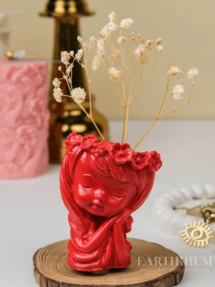 The red figurine holder styled as a mini vase with delicate dried baby's breath. It's a simple way to add a touch of lasting beauty to any small space.