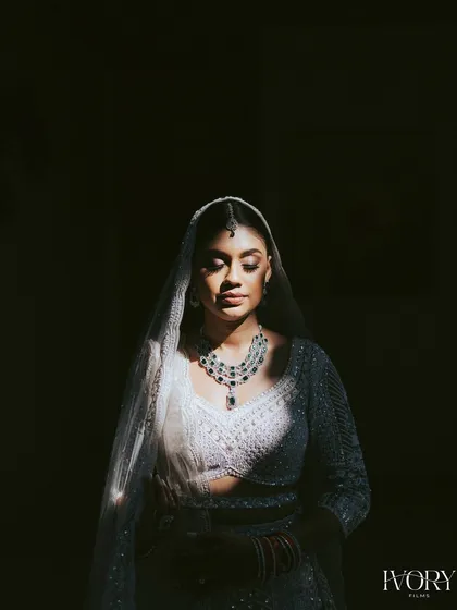 A study in light and shadow. This artistic bridal portrait uses a single sliver of light to illuminate the bride's face and jewelry, creating a dramatic and soulful image.