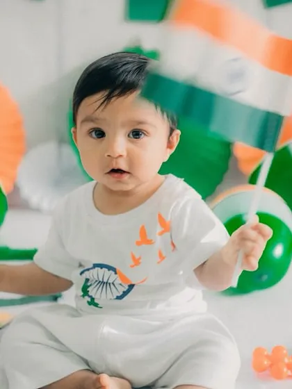 Here, a curious baby proudly holds up the Indian flag. The direct eye contact and adorable expression make this a heartwarming memory from a patriotic-themed baby photoshoot in my Mumbai studio.