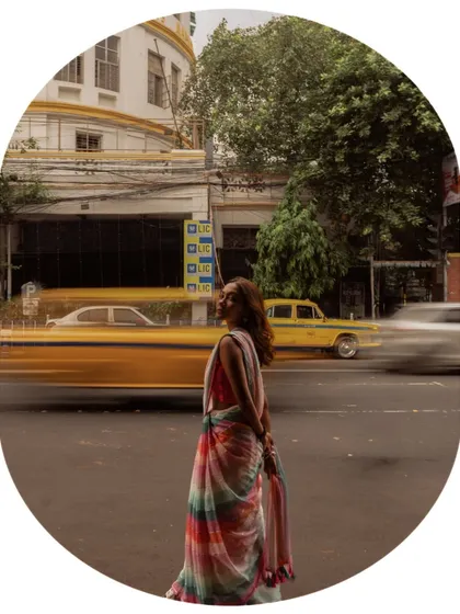 A creative shot for AVA India using a long exposure to capture the motion of a yellow taxi. The model stands still, a calm presence amidst the city's hustle.