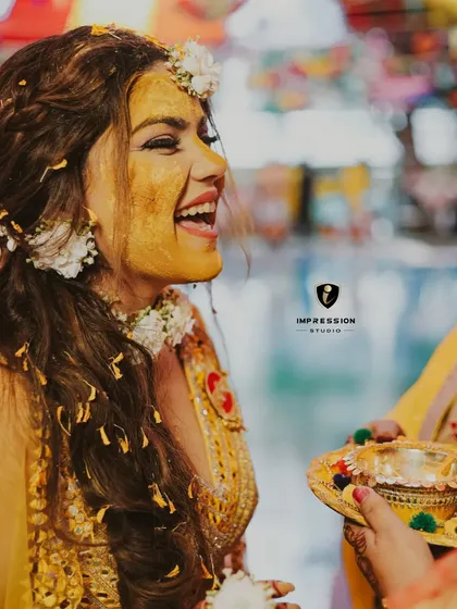 Haldi suits her! The bride's face is covered in turmeric, and her laugh is infectious. A perfect candid moment from a fun haldi ceremony in Bhimtal.