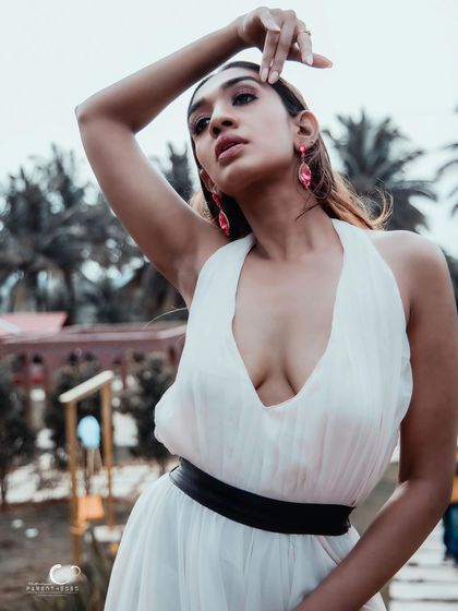 A confident and striking pose against a backdrop of palm trees. This portrait has a tropical, high-fashion feel.