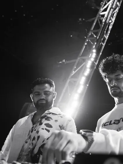 A black and white shot of me and Kayvee during a B2B set for a NOBO experience. The focus is purely on the music and our interaction.