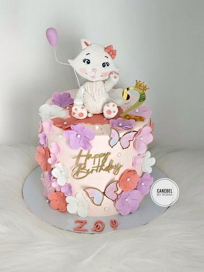 A pretty-in-pink cat-themed cake for a cat lover named Zoy. The cake is adorned with a cute fondant cat, flowers, and butterflies.