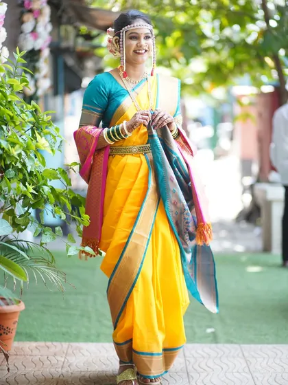 The bride's grand entrance, looking every bit the part of a Maharashtrian queen. The yellow Nauvari is draped to perfection for a graceful walk.