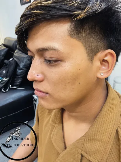 A profile view of a male client with a fresh nose piercing. I offer piercing services for everyone, ensuring a professional experience.