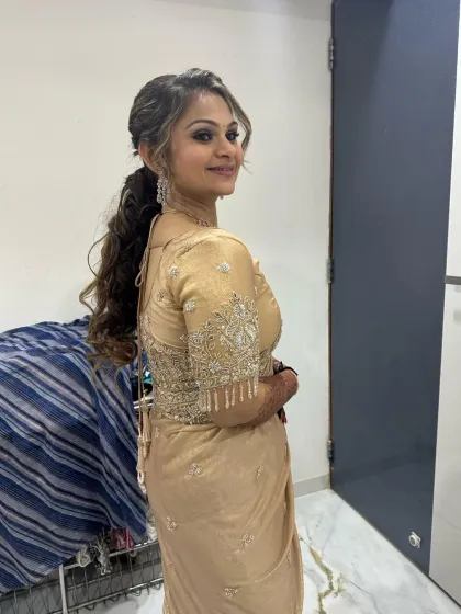 A smiling portrait of the client, showing off her complete look. The makeup is subtle yet glamorous, perfect for any party.
