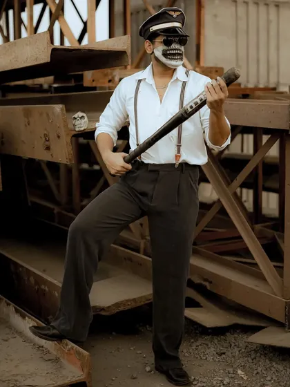 A full-body shot that showcases the entire stylized outfit, including the suspenders and pilot hat.