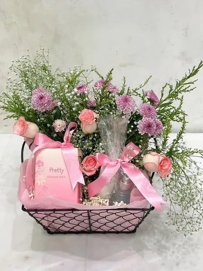 A simple yet perfect way to celebrate any occasion. This wire basket with pink roses and a beautifully wrapped gift is a classic gesture of affection.