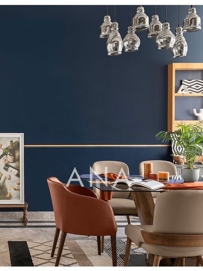 The dining area in Apartment 704 is designed to be a vibrant hosting space. The composition of the glass table, colorful chairs, and statement wall creates a playful yet sophisticated atmosphere.
