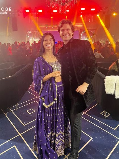 This couple is ready for a party. He is wearing a black velvet bandhgala jacket with intricate embroidery, a luxurious choice for a cocktail night or reception.