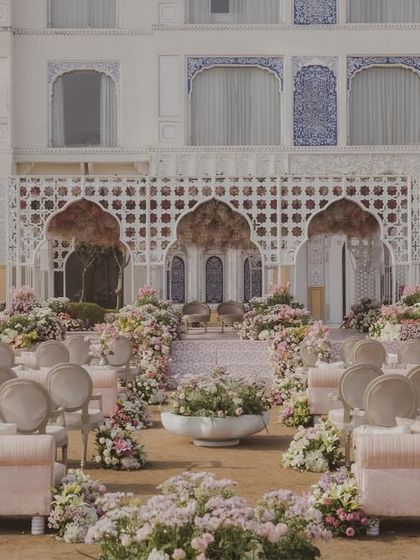The full wedding ceremony setup against the magnificent facade of The Leela Palace Jaipur. The decor's pastel palette beautifully complements the hotel's architecture.