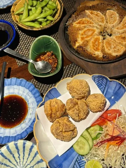 A table full of our favorite appetizers. This spread includes crispy chicken karaage, edamame, and our signature Hanetsuki Gyoza, perfect for sharing.