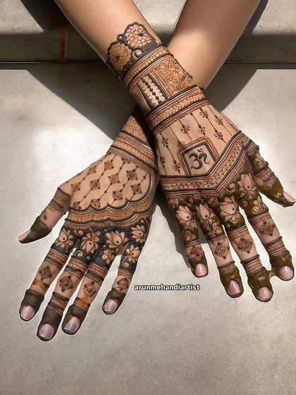 A spiritual and elegant design featuring the 'Om' symbol. This henna combines sacred elements with beautiful lotus and jaali patterns, perfect for a bride seeking a meaningful design.
